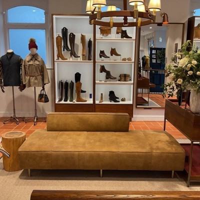 Freestanding Seat in brown suede leather within shoe store