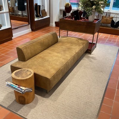 Freestanding Seat in brown suede leather within shoe store
