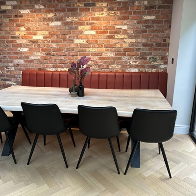 Fluted back banquette in leather against natural wall