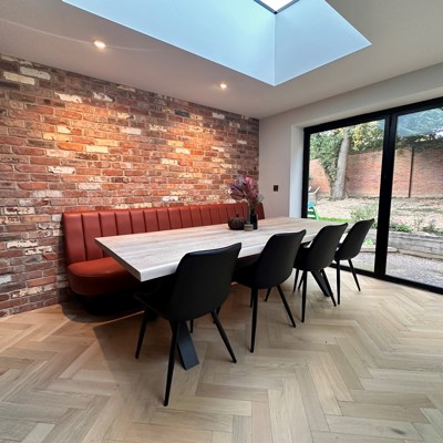 Fluted back banquette in leather against natural wall