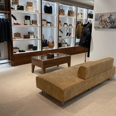 Freestanding Seat in brown suede leather within shoe store